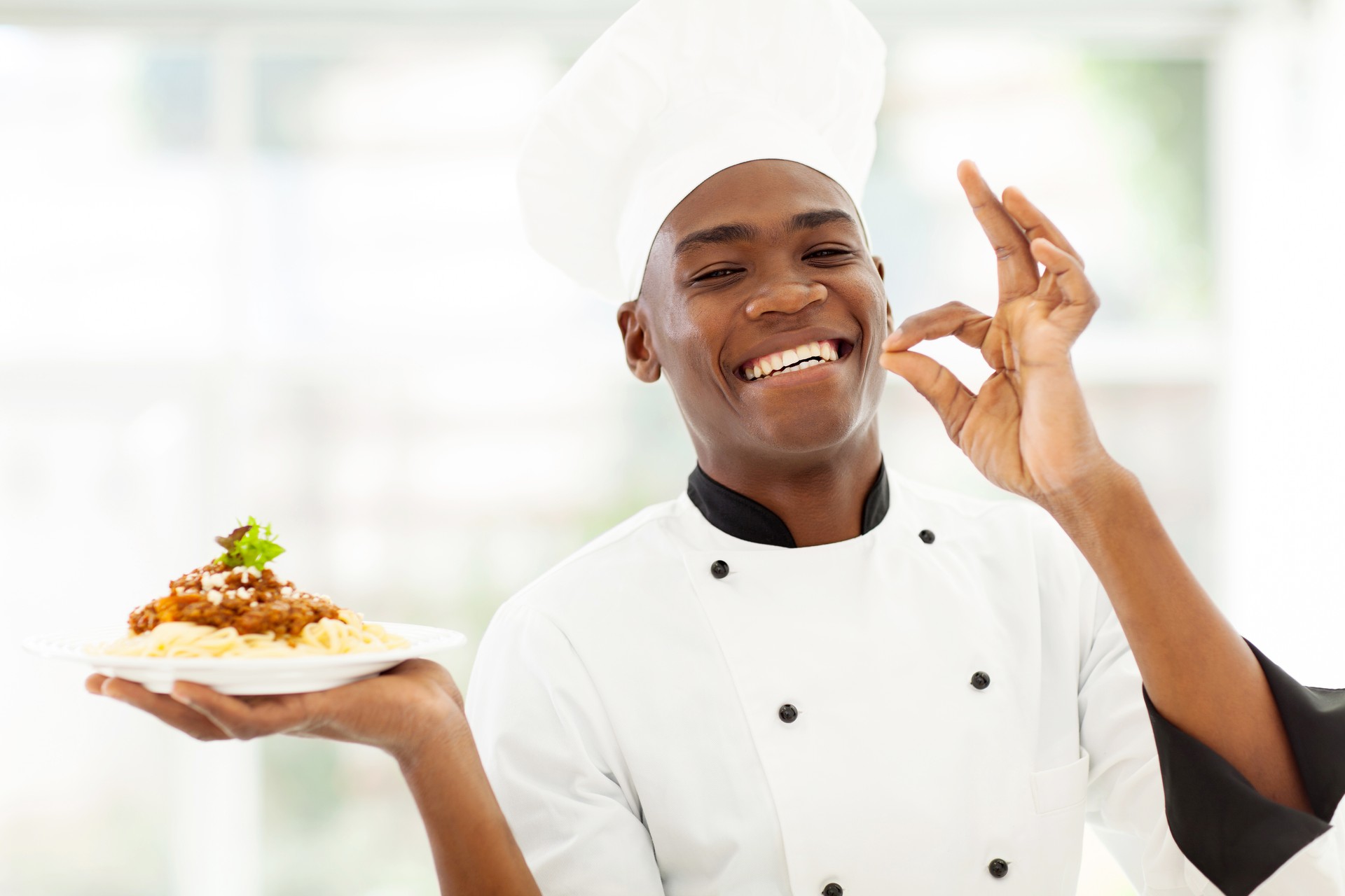 professional African chef holding delicious spaghetti