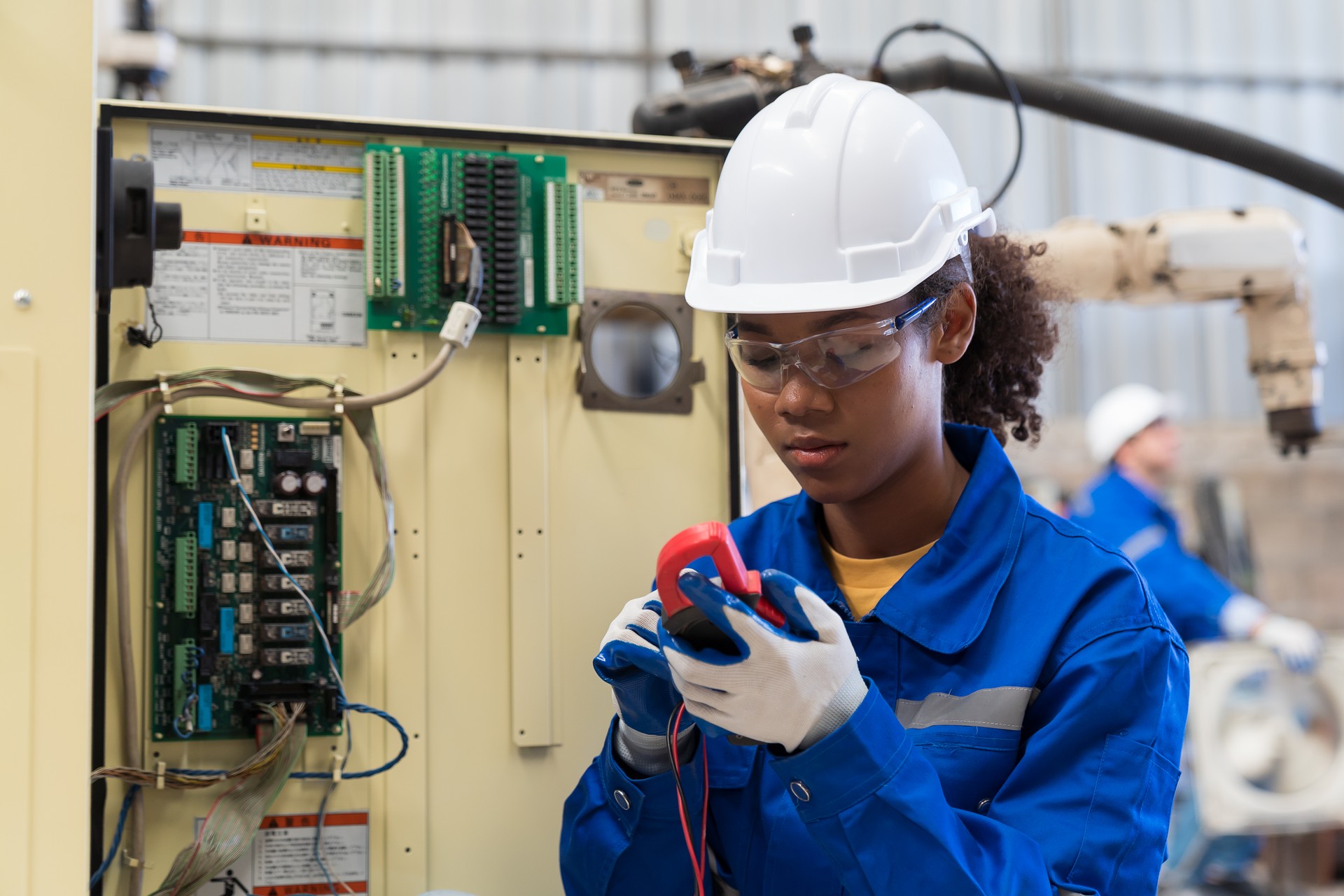 Female electrician worker checking, repair, maintenance operation electric system in the factory. Woman electrician engineer working with operation electric system at production line